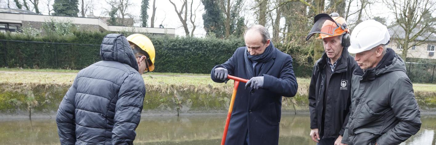 Minister Ben Weyts en burgemeester Wim Dries steken bij hun werfbezoek een handje toe: ze hielpen de vrijwilligers bij de renovatiewerken van de Slagmolen in Genk.