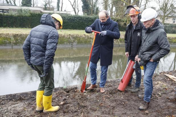 Minister Ben Weyts en burgemeester Wim Dries steken bij hun werfbezoek een handje toe: ze hielpen de vrijwilligers bij de renovatiewerken van de Slagmolen in Genk.