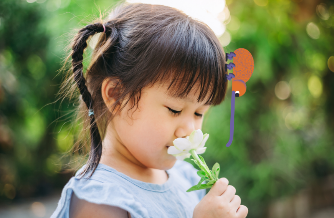 meisje ruikt aan bloem